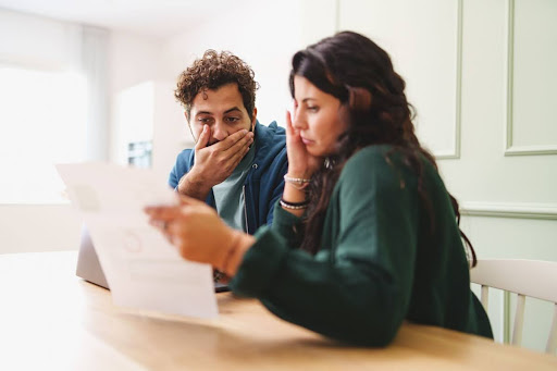 Couple worrying looking over electrical bill.